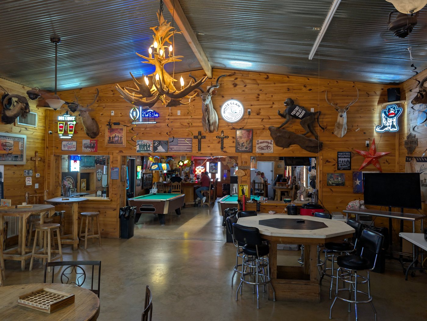 Inside Headwaters Saloon: antler chandelier, mounted trophies, neon beer signs and pool tables